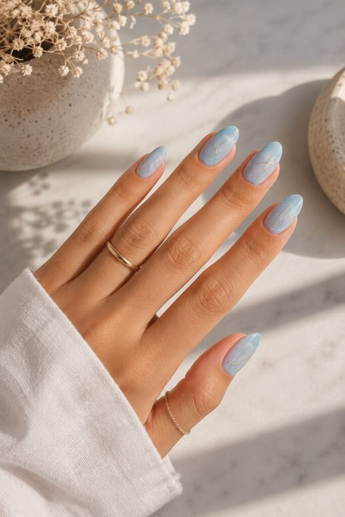 Icy Blue Marble Almond Nails With Silver Accents
